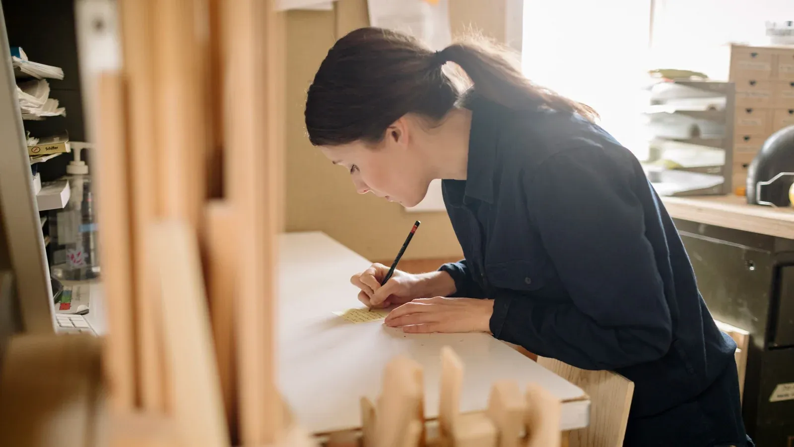 Une femme remplit un document sur un établi d'atelier