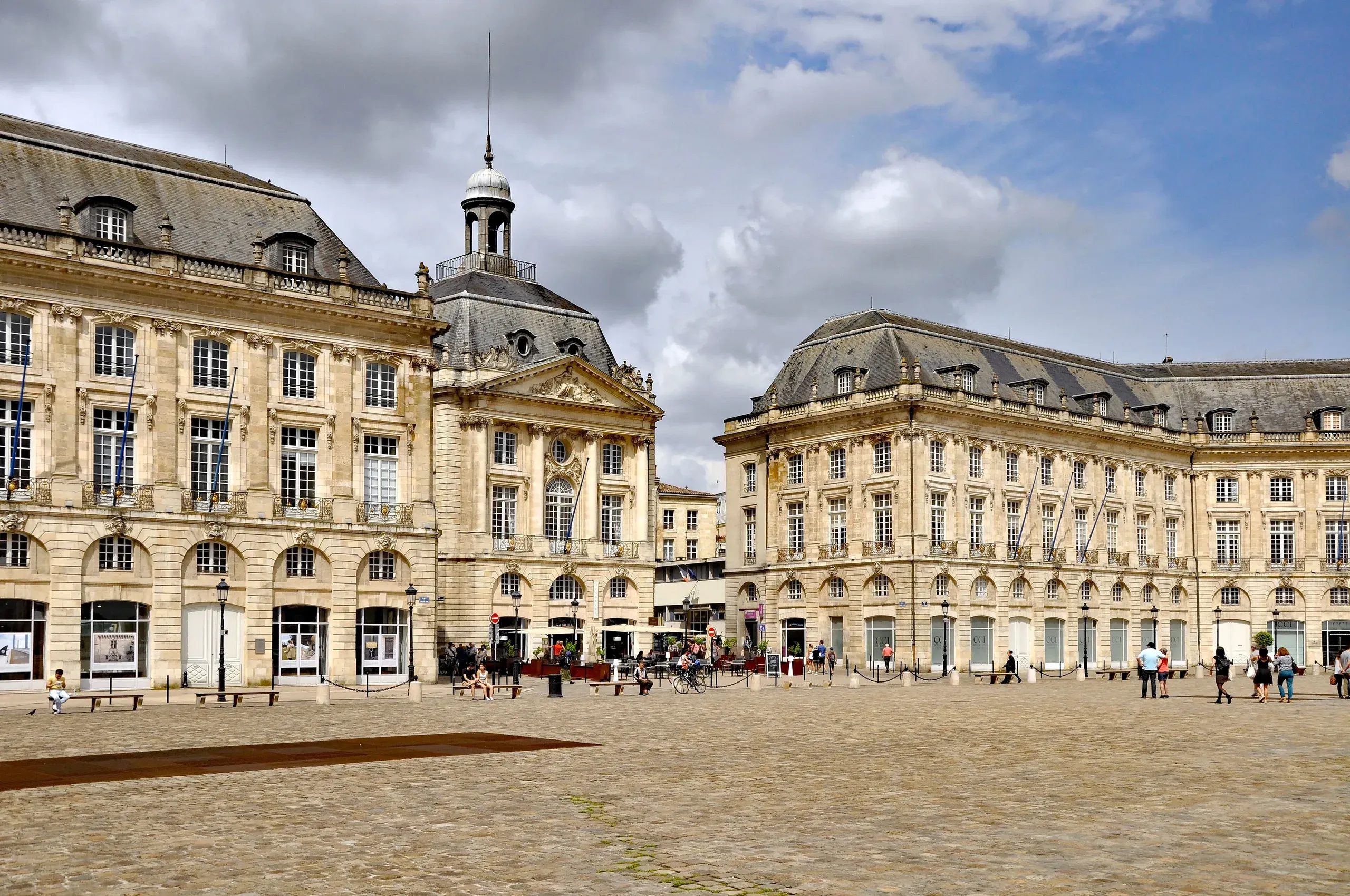 La place de la Bourse à Bordeaux, ses façades classiques en pierre blonde sous un ciel nuageux
