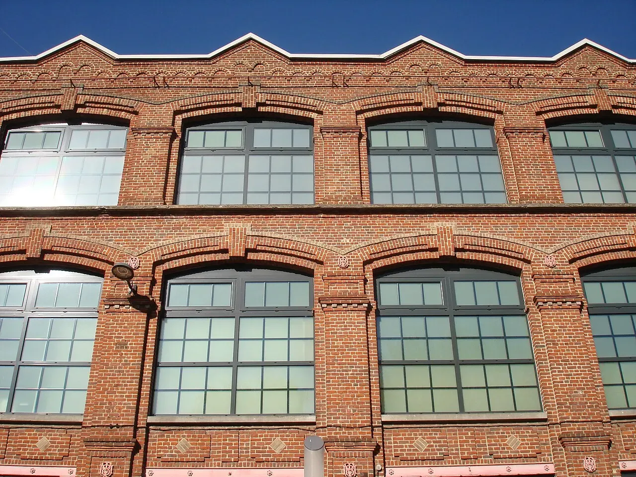 La façade en brique de l’ancienne usine de velours de Roubaix, reconvertie en magasins