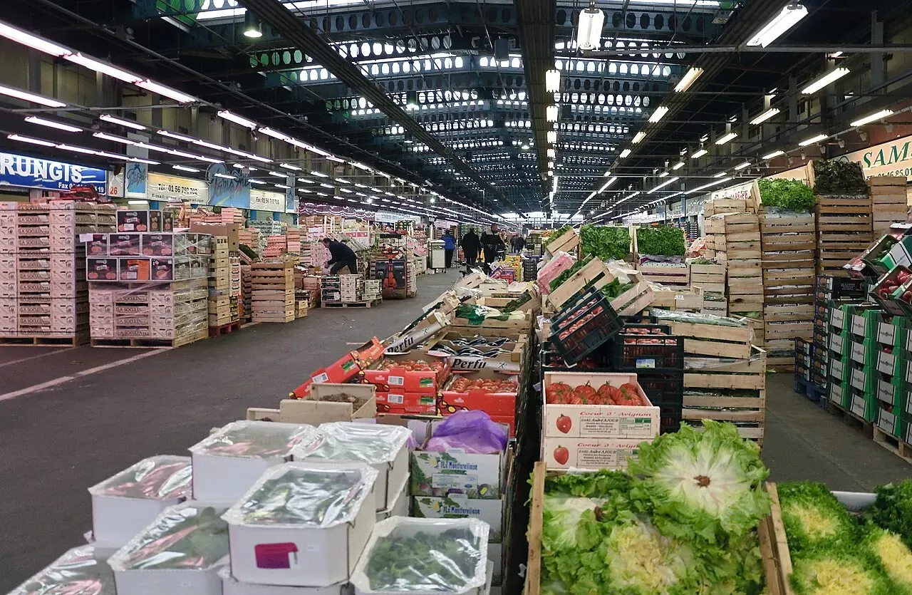 Une allée du pavillon des fruits et légumes du marché de Rungis, bordée de cagettes