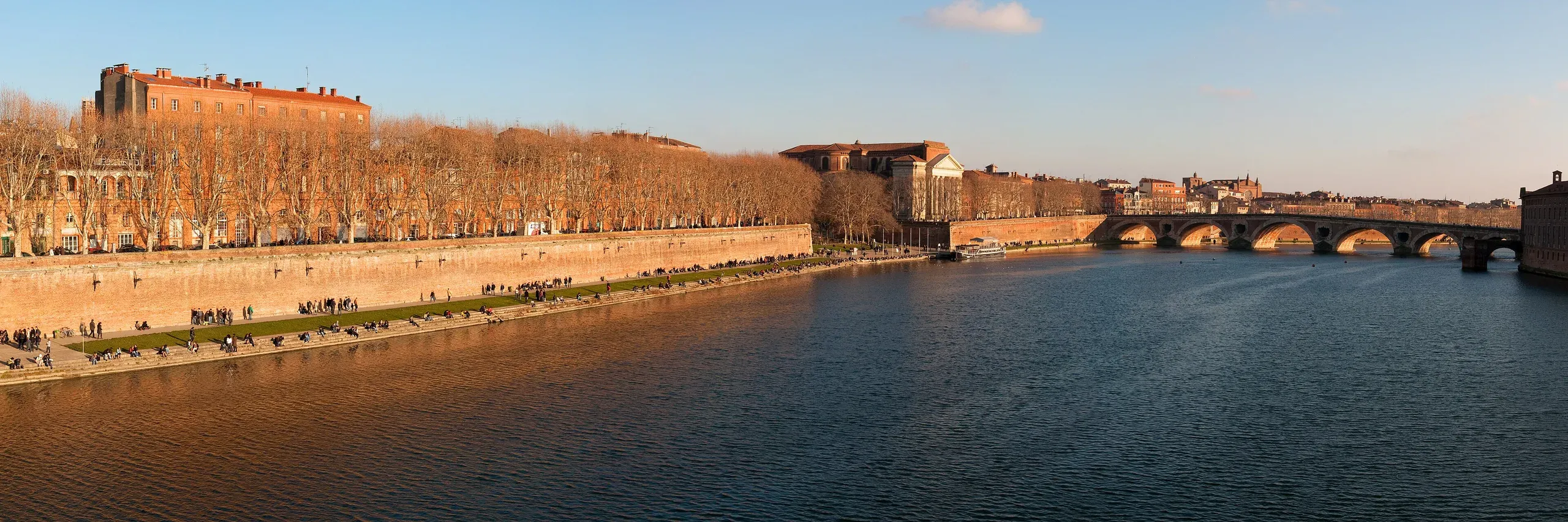 Les quais de la Garonne à Toulouse en fin d’après-midi : façades de brique, basilique de la Daurade et Pont-Neuf au loin