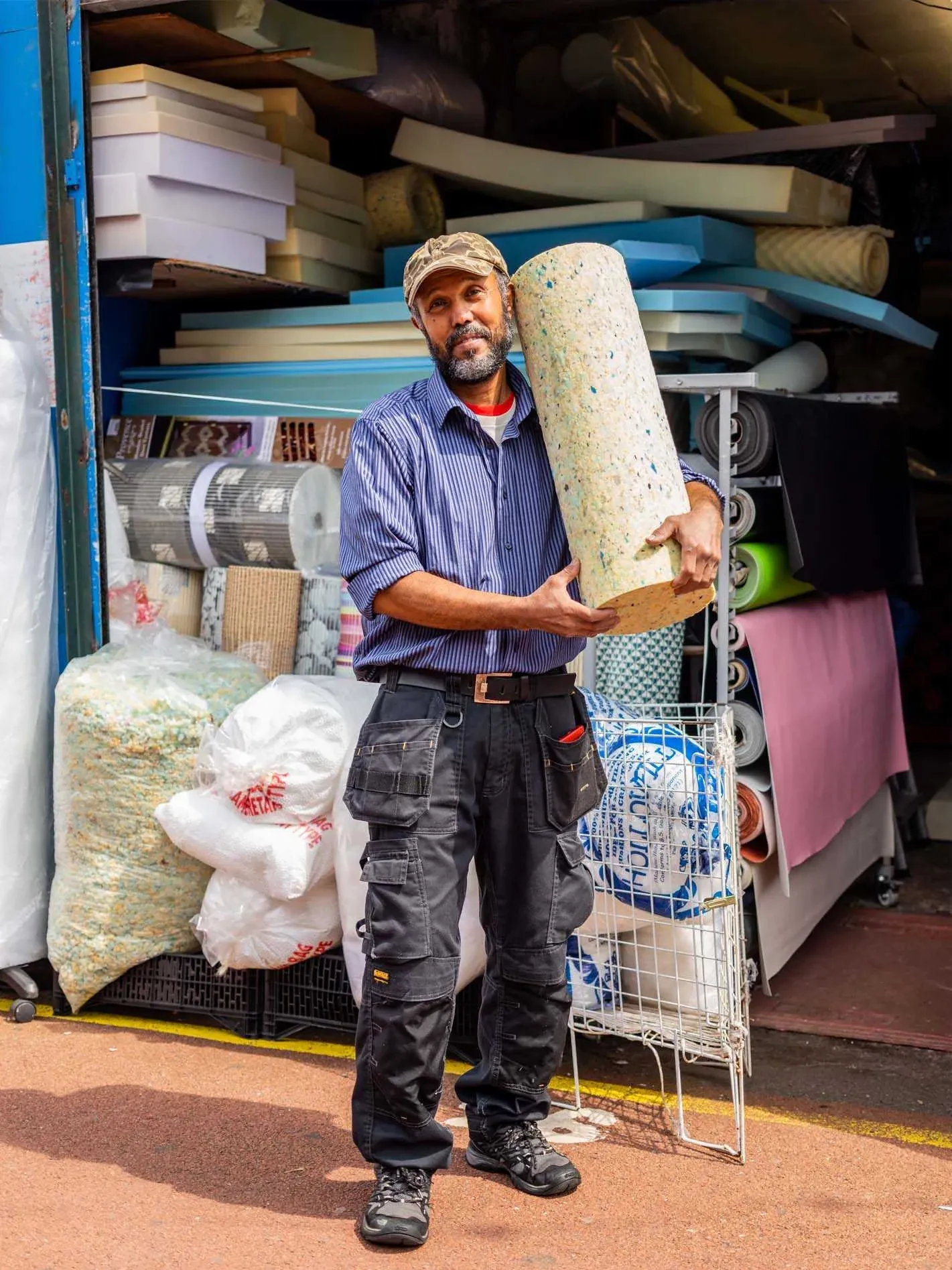 Un magasinier en tenue de travail bleue devant une réserve de marchandises